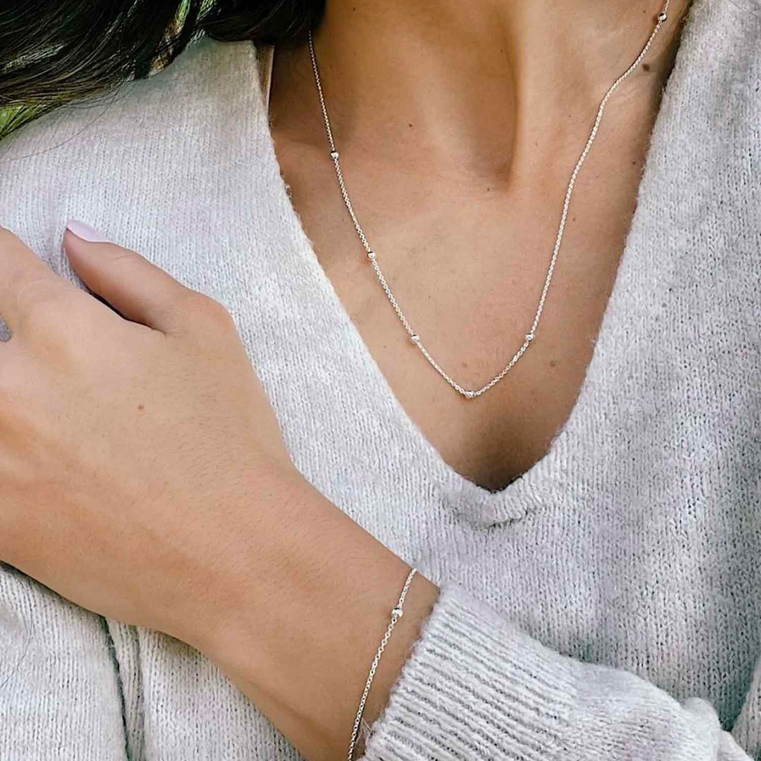 Modelo con pulsera y collar de plata - GOLD SHIELD