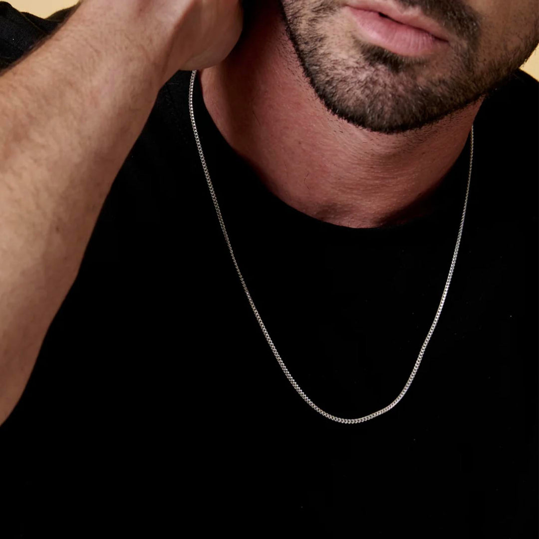 Modelo con playera negra y cadena de plata tipo cubana 2mm - GOLD SHIELD