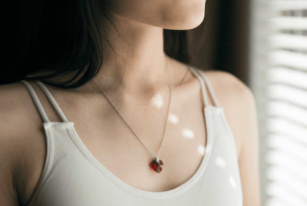 Collar relicario , corazón rojo en cuello de modelo marca GOLD SHIELD