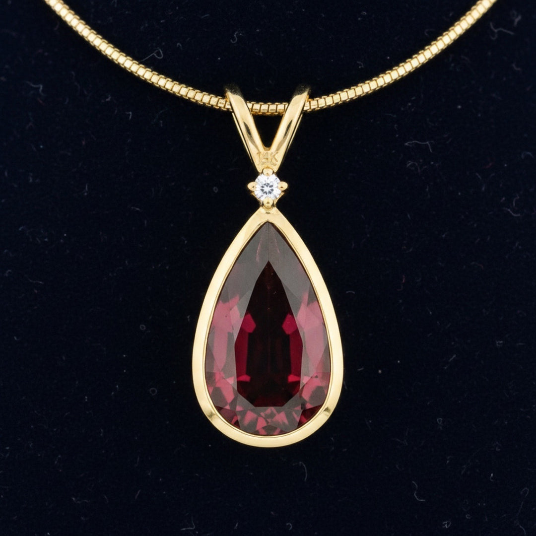 dije de oro 14k con granate rhodolita rosado rojo natural 3.48ct corte pera de Africa, joyería mexicana Gold Shield