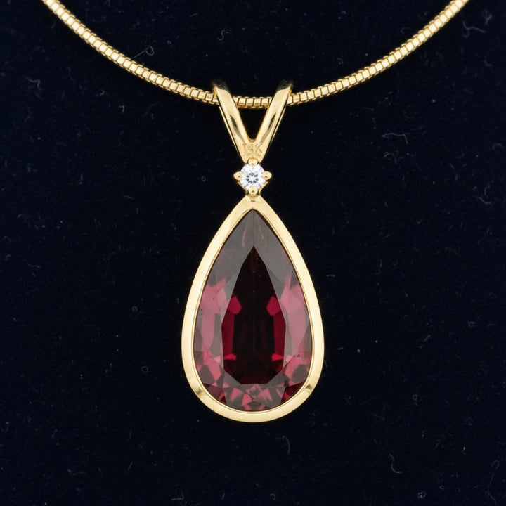 dije de oro 14k con granate rhodolita rosado rojo natural 3.48ct corte pera de Africa, joyería mexicana Gold Shield
