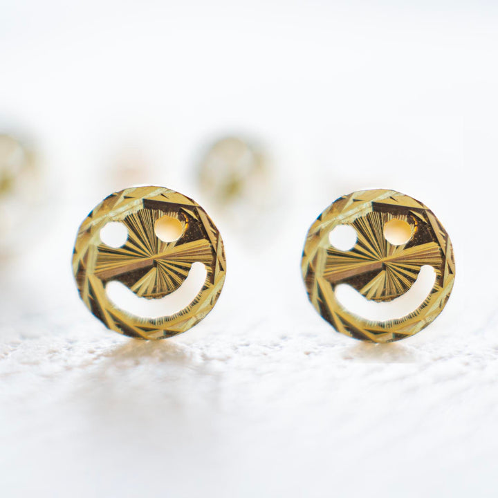 ARETES ORO 18 KILATES EN FORMA DE CARITAS SONRIENTES CON FONDO BLANCO MARCA GOLD SHIELD