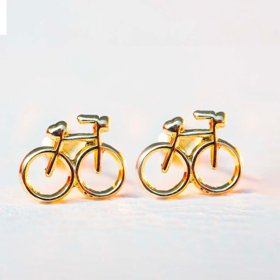 Aretes de oro en forma de bici en fondo blanco